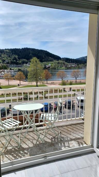 une vue d'un balcon avec une table et des chaises dans l'établissement La parenthèse du lac, à Gérardmer