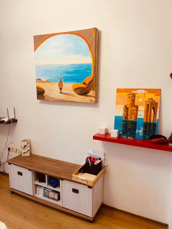 a room with a painting on the wall and a table at Студия Мир Авангарда in Sunny Beach