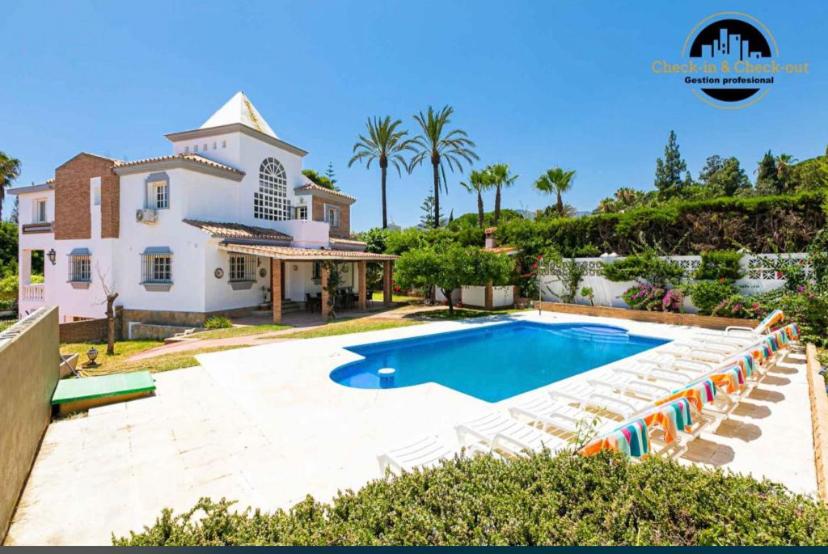 a villa with a swimming pool and a house at Villa del Mar in Torremolinos