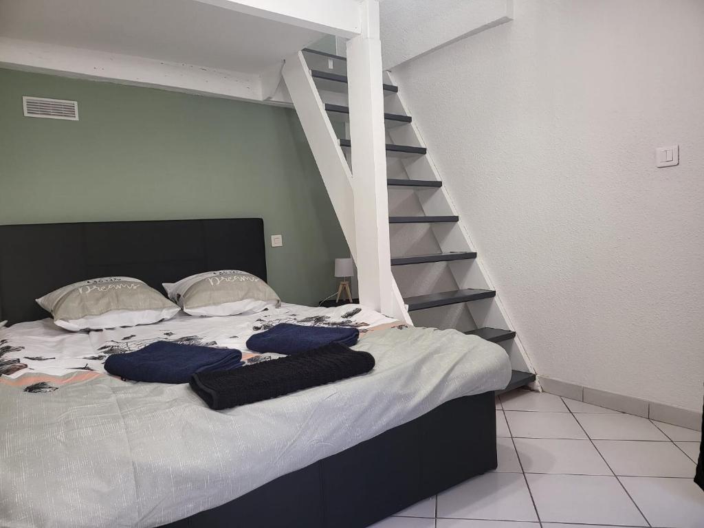 - une chambre avec un lit doté d'oreillers bleus et un escalier dans l'établissement studio amande, proche gare, wifi, à Agen