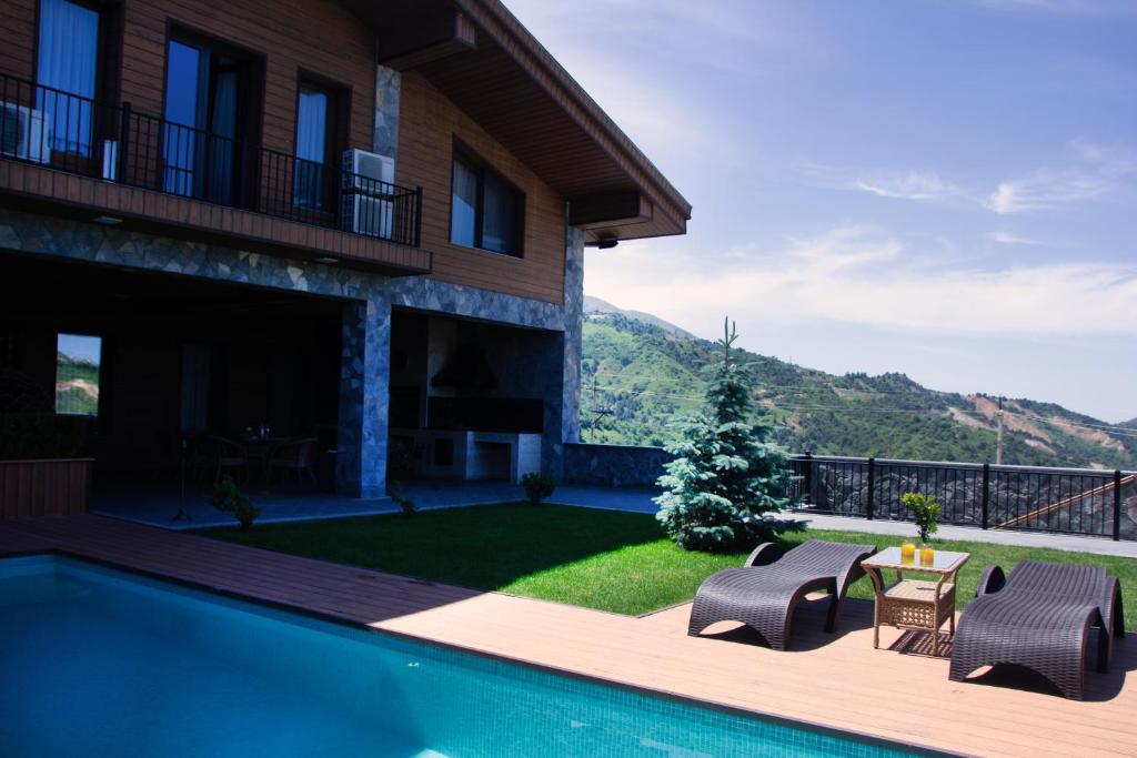a villa with a swimming pool and a house at Shamuk Homes in Chimgan