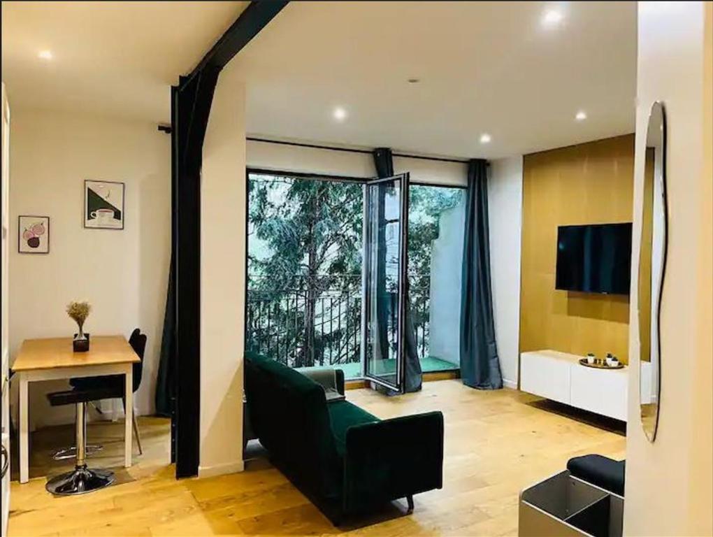 - un salon avec une chaise verte et un bureau dans l'établissement Appartement Paris 11 - 2 chambres - 2 sdd - 2 wc, à Paris