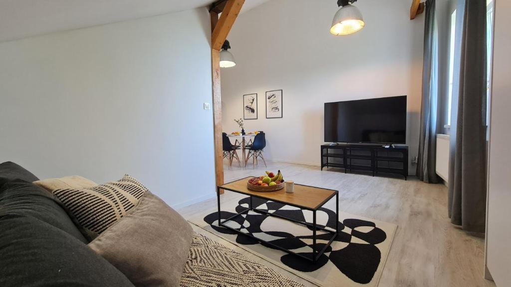 a living room with a couch and a table at Apartament Quiet Street 11, 6E in Oświęcim