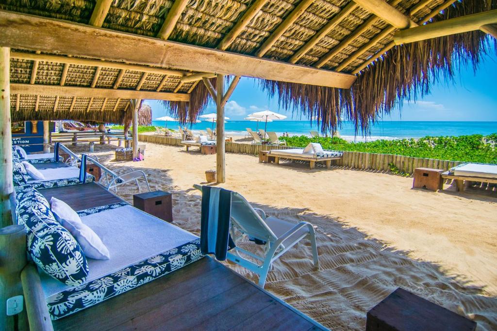 - une plage avec un lit et des chaises sur la plage dans l'établissement Pousada Tangará, à Trancoso