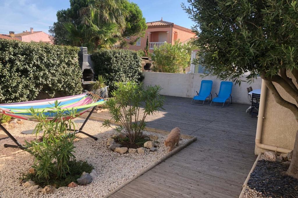 - un hamac dans un jardin avec un chien et des chaises dans l'établissement House with garden and terrace near beach, à Port-la-Nouvelle