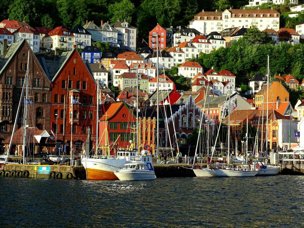 a group of boats docked in a harbor with buildings at Home Hotel Bryggen in Bergen