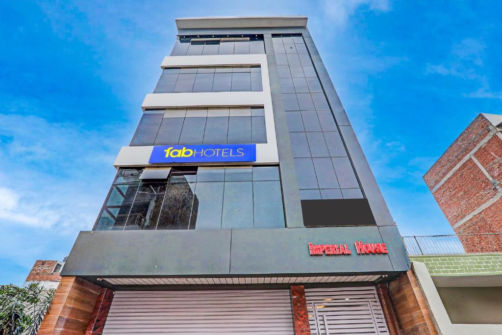 a tall building with a sign on it at FabHotel Imperail House in Prayagraj