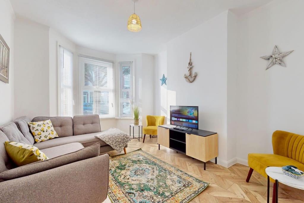 ein Wohnzimmer mit Sofa und Fernseher in der Unterkunft Bright & Spacious 4 Bed Victorian Home by Blue Buzzard Property in Kent