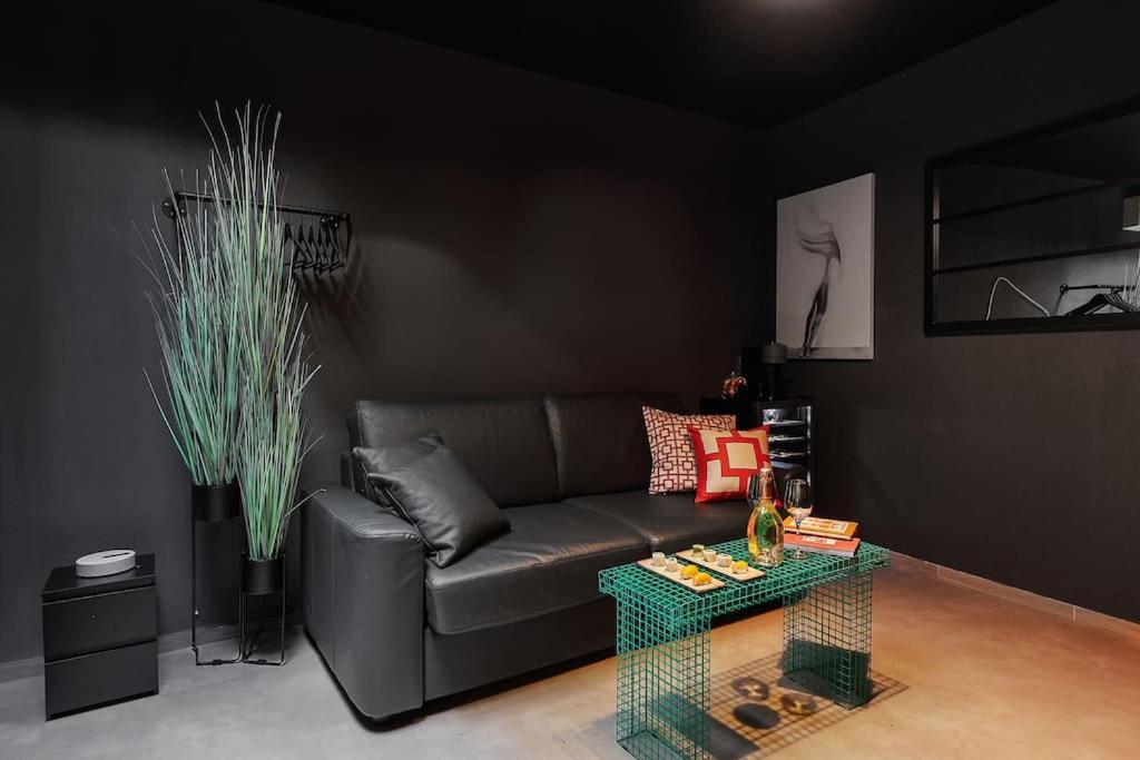 un salon avec un canapé et une table dans l'établissement Le Dark, à Paris