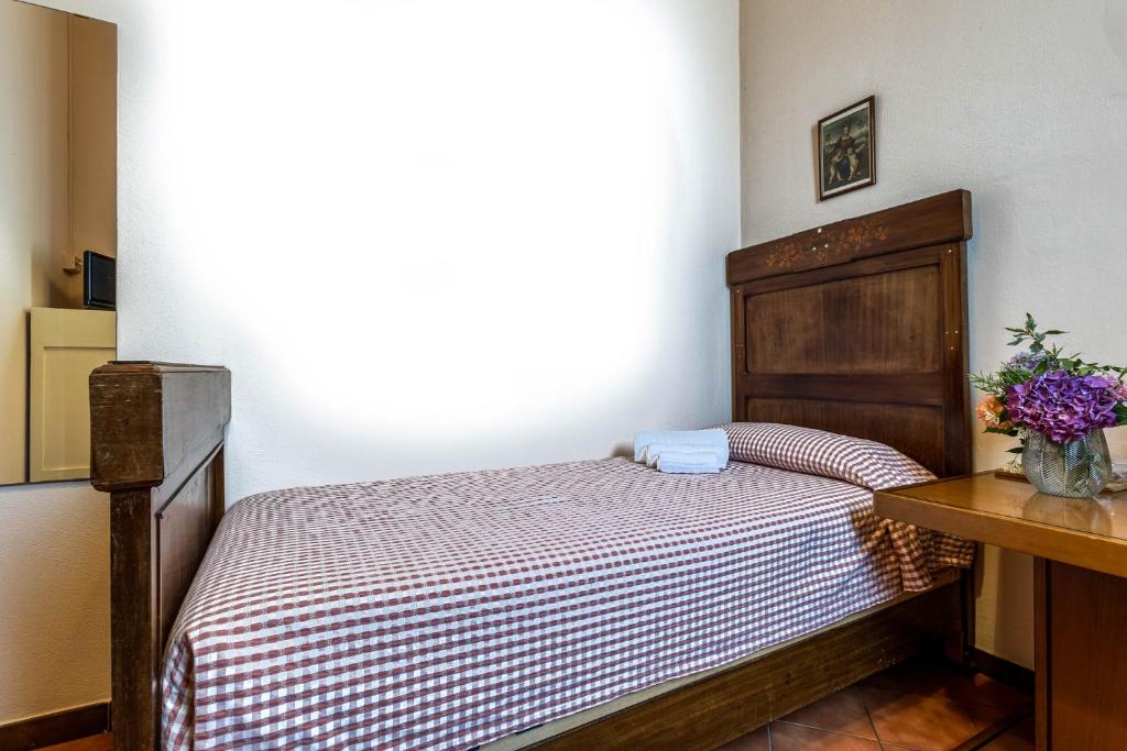 a small bedroom with a bed and a table at Cascina Gaggioli in Milan