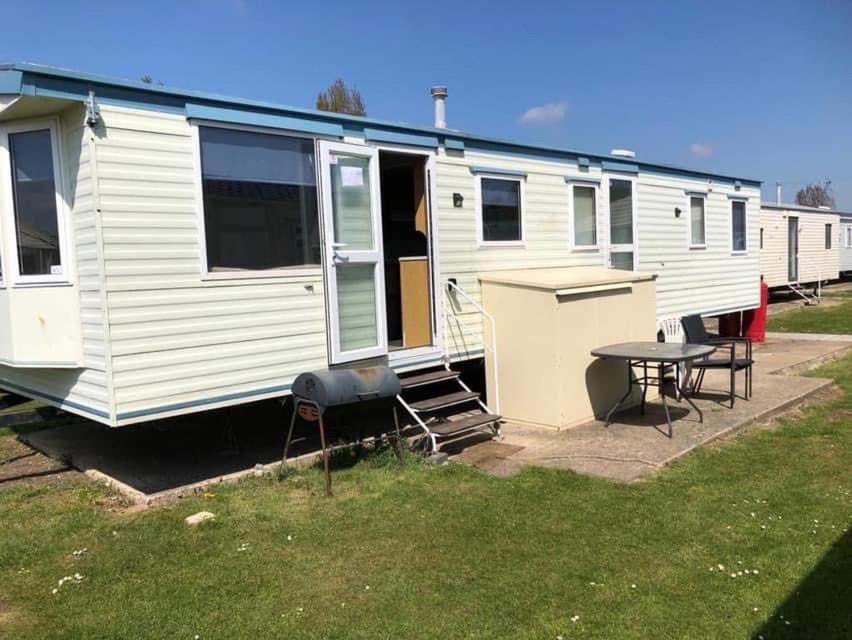 ein weißes Wohnmobil mit einem Picknicktisch und einem Tisch in der Unterkunft 361 seawick in Saint Osyth