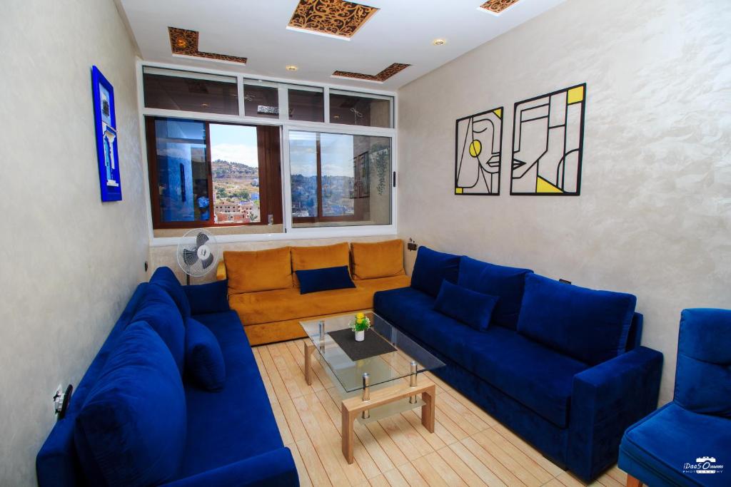 a living room with a blue couch and a table at casa chaouen in Chefchaouen