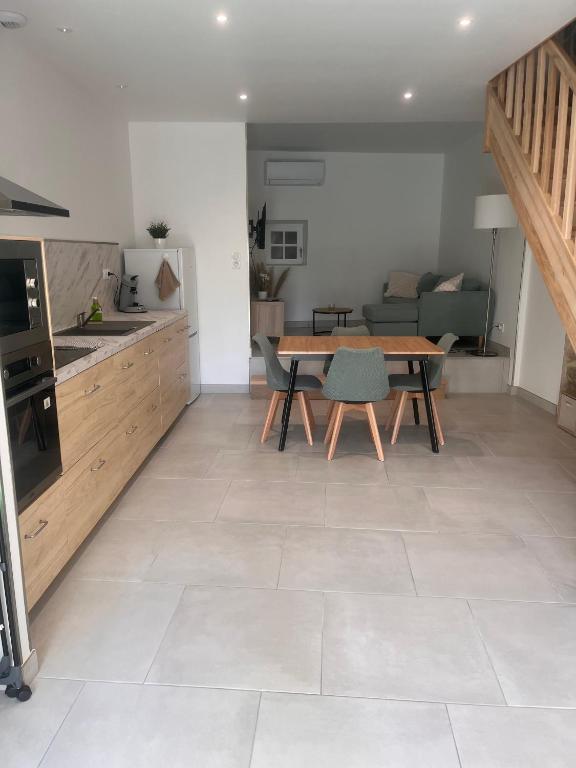 un salon avec une table et une cuisine dans l'établissement Maison de ville - La Sauvetat, à La Sauvetat
