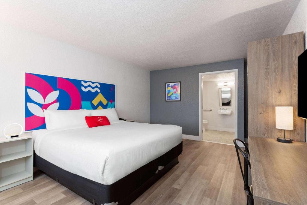 Un dormitorio con una cama grande con un cuadro en la pared. en Howard Johnson by Wyndham Orlando Lake Buena Vista South, en Kissimmee
