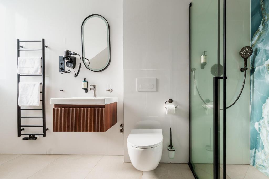 a bathroom with a toilet and a sink and a shower at Esplanade Carlsbad in Karlovy Vary