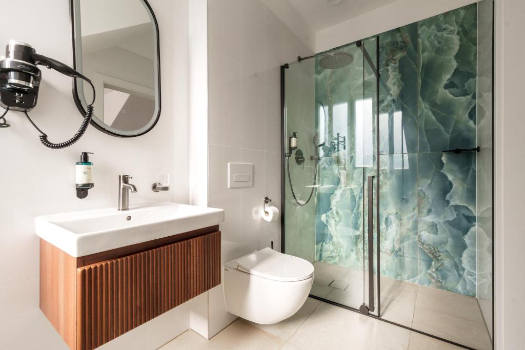 a bathroom with a shower and a toilet and a sink at Esplanade Carlsbad in Karlovy Vary