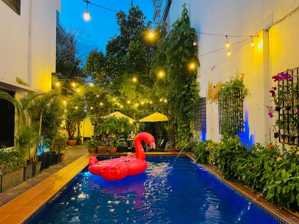 a pool with a red swan in a yard at Birdcage Boutique in Phnom Penh