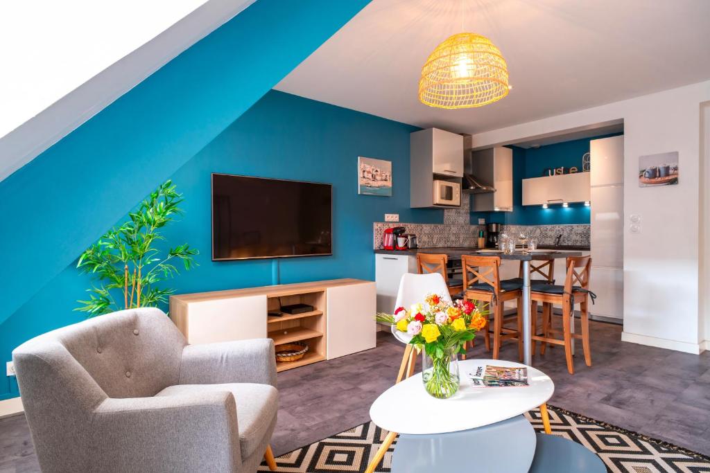 a living room with a blue accent wall at Le Saint-Patern - T3 centre-ville et garage sécurisé in Vannes