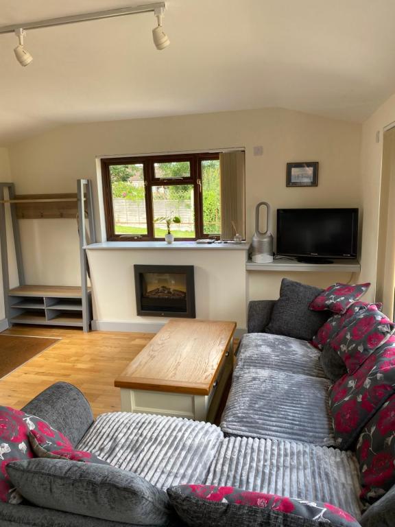 a living room with a couch and a table at Cottage Retreat- Sleeps 4 Garden in Sherborne