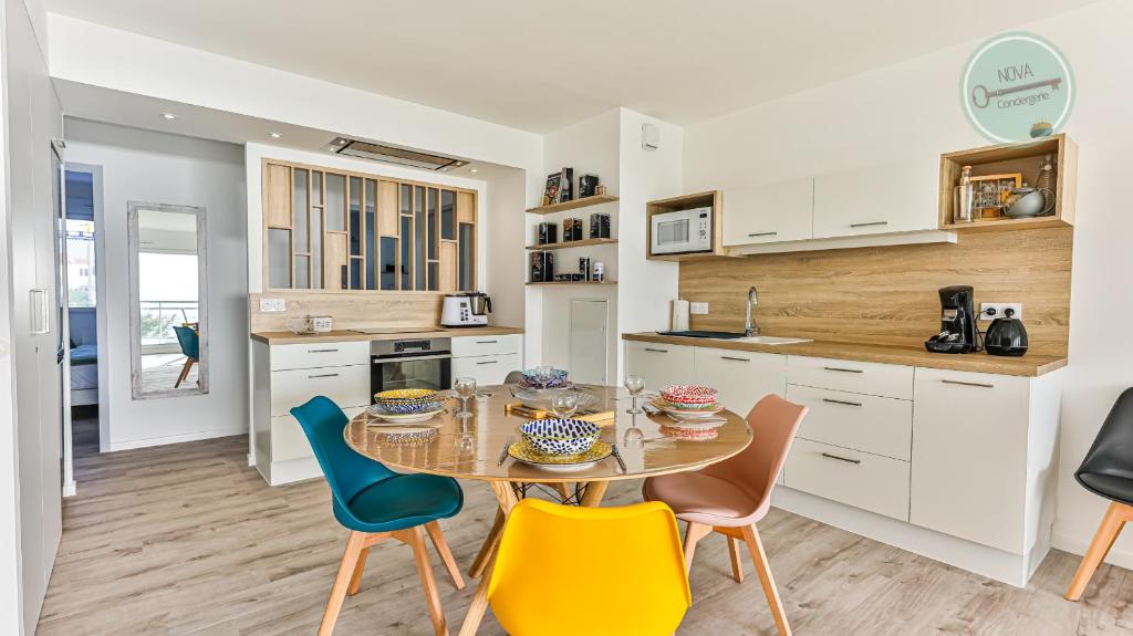 une cuisine et une salle à manger avec une table et des chaises dans l'établissement Les Tamaris de l Atlantide, à Saint-Hilaire-de-Riez