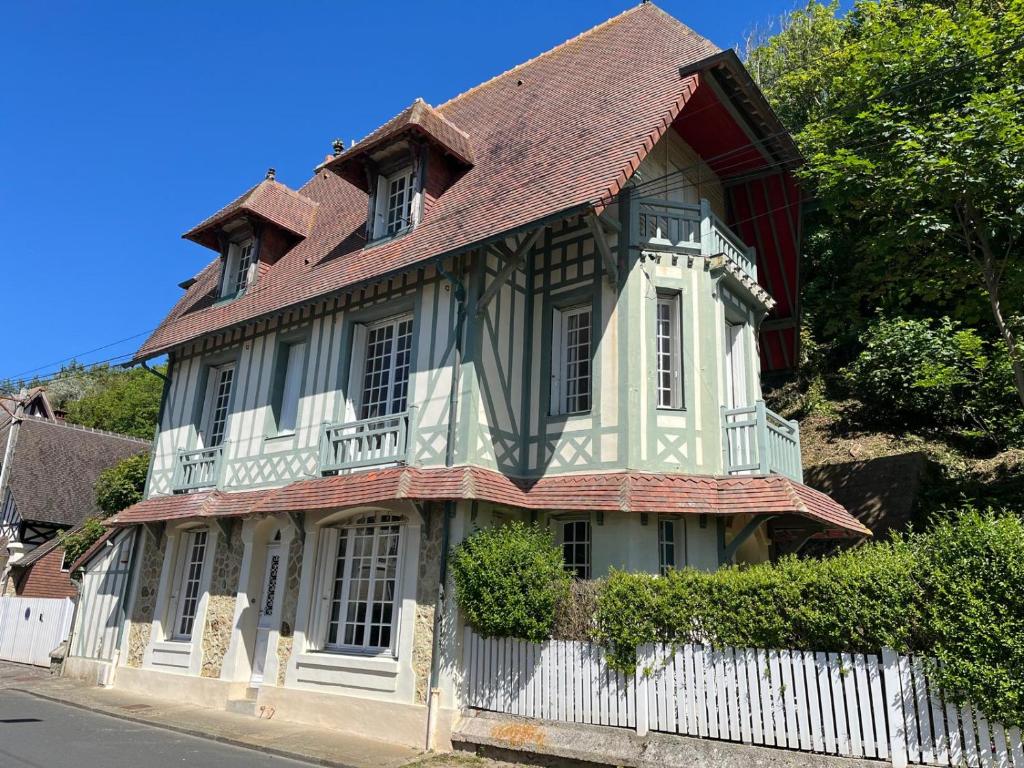 une vieille maison avec une clôture blanche dans l'établissement Villa La Petite Normandy Vue Mer, à Trouville-sur-Mer