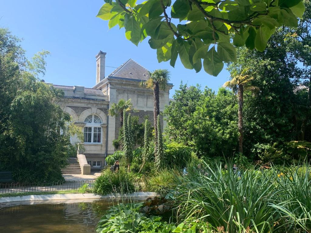 an old house with a pond in front of it at La Passerelle in Cherbourg en Cotentin