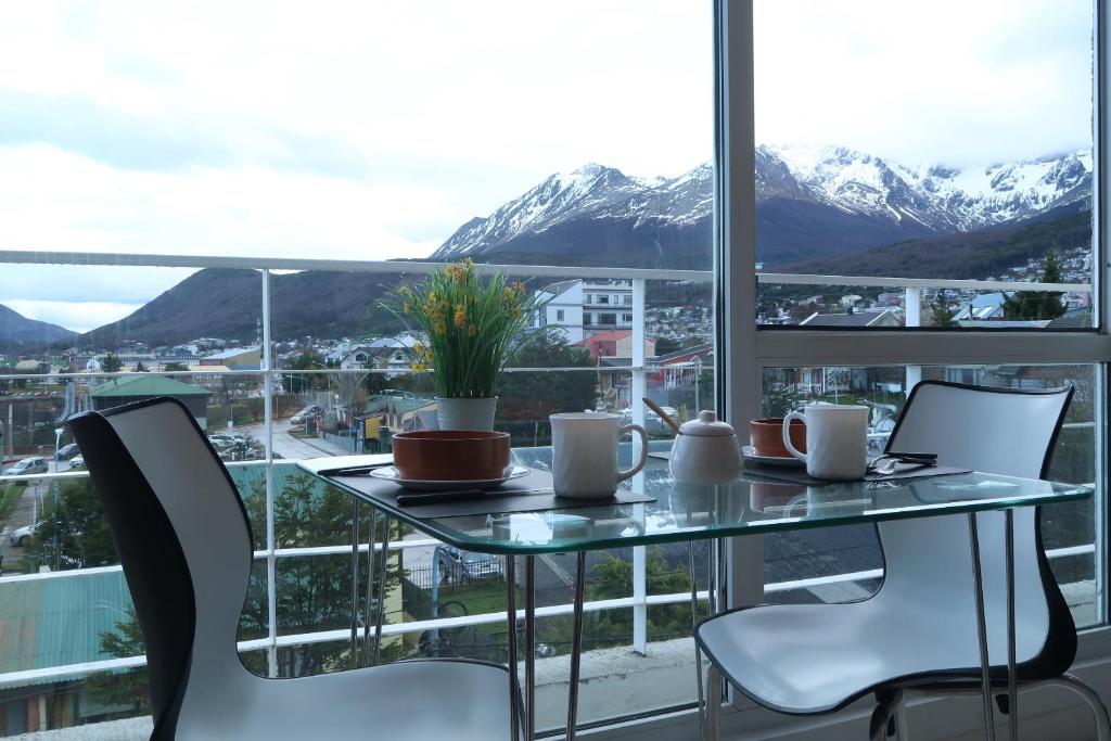 a table and chairs with a view of mountains at Josefina in Ushuaia