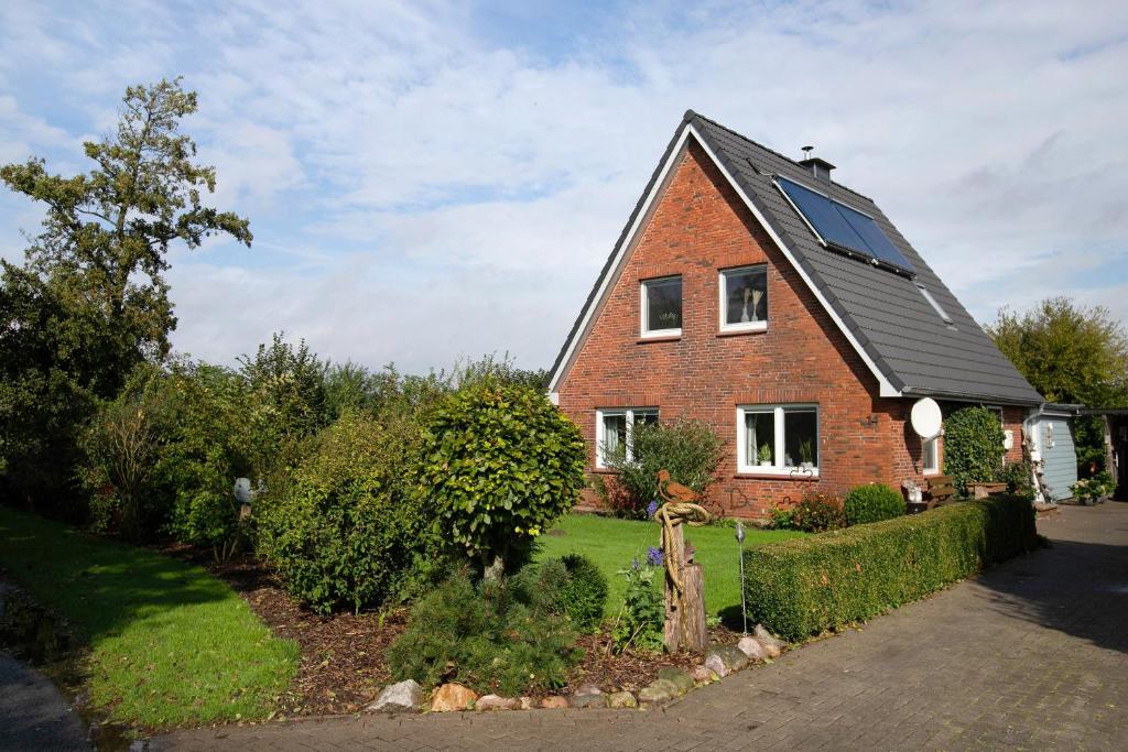 a red brick house with a black roof at Hus an Diek in Hillgroven