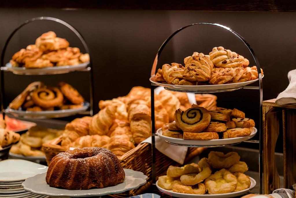a bunch of different types of pastries on shelves at Motel One Hamburg Airport in Hamburg
