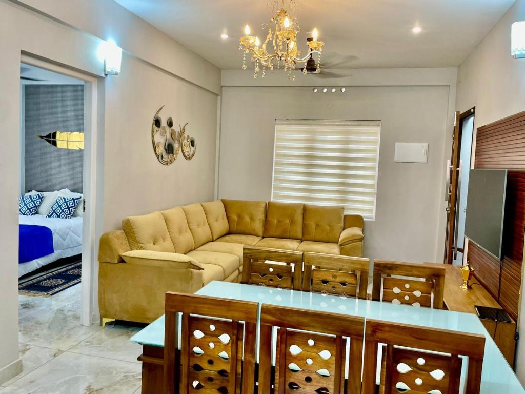 a living room with a couch and a chandelier at 88 HOMES Near LULU MALL EDAPALLY in Cochin