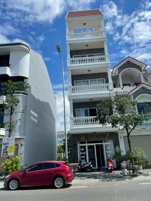a red car parked in front of a building at Homestay Ocean Real in Phan Thiet