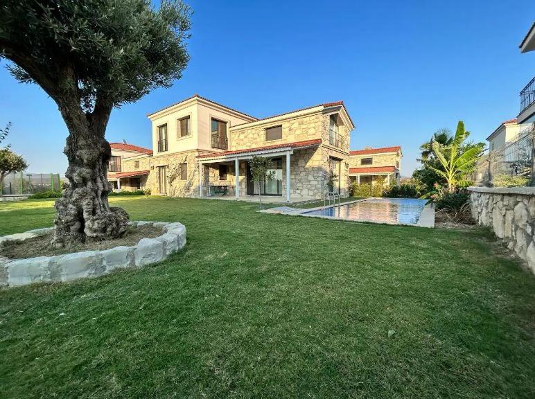 una casa con un albero in mezzo al cortile di Villa Hisar a Seferihisar