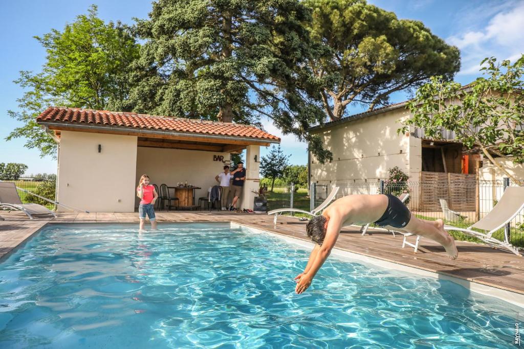 Un homme sautant dans une piscine dans l'établissement Le Mazage des Trégans, à Gaillac