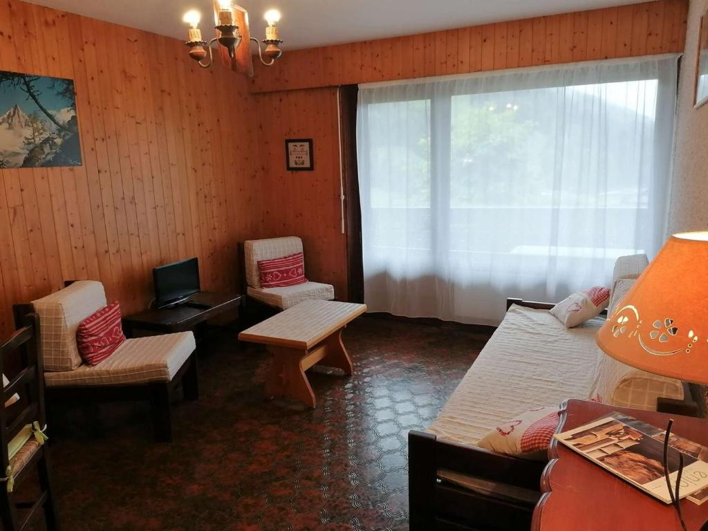 - une chambre avec 2 lits, des chaises et une fenêtre dans l'établissement Studio en Rez-de-Jardin pour 4 avec Parking Couvert, à 500m de la Télécabine - Le Grand-Bornand - FR-1-241-80, au Grand-Bornand