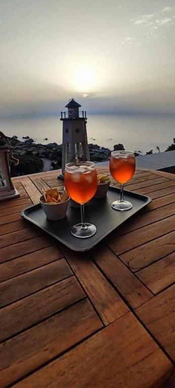 a tray with two drinks on a table with a lighthouse at Villa Mamia Pool Costa Paradiso in Costa Paradiso