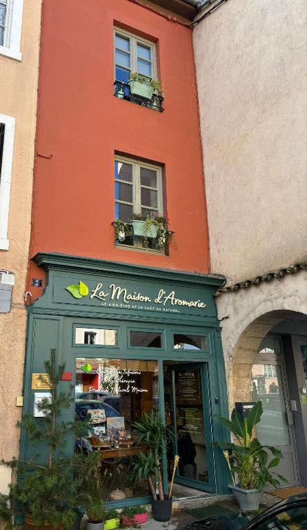un magasin devant un bâtiment avec des plantes devant dans l'établissement La Maison d’Aromarie, à Tournus