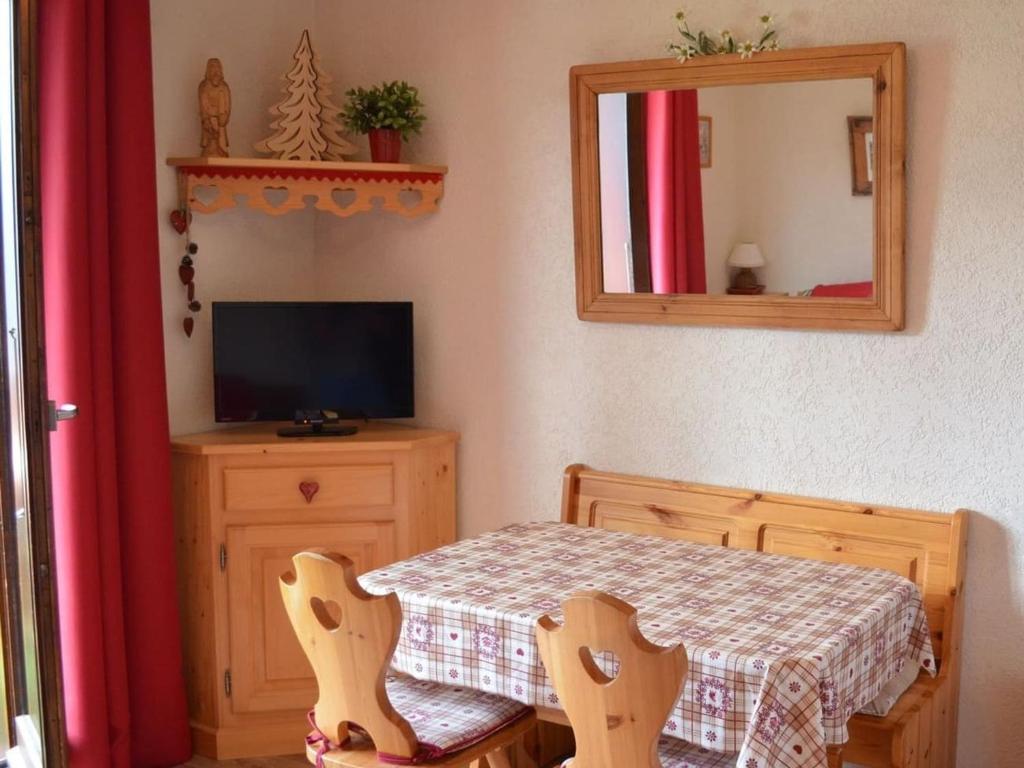 une salle à manger avec une table et un miroir dans l'établissement Studio cosy avec balcon, 3 pers, à 750m des remontées mécaniques, parking et casier à skis inclus - FR-1-676-165, à Châtel