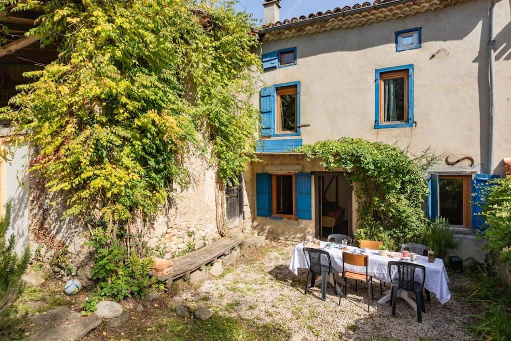 une table et des chaises devant une maison dans l'établissement Gîte de la Tour pour 10 personnes à Ganac, à Ganac