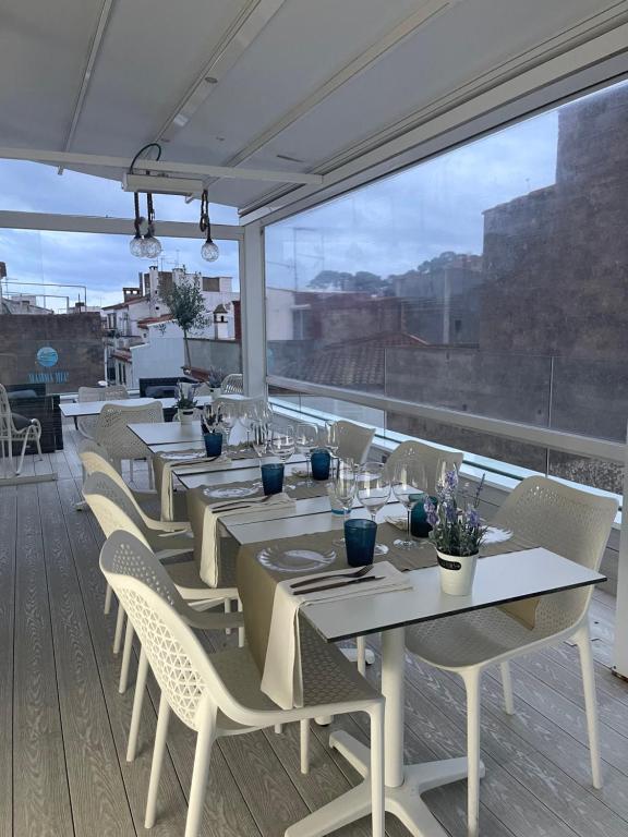 a dining room with tables and chairs and a large window at Mamma Mia Hotel Boutique - Only Adults in Tossa de Mar