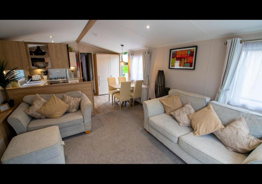 a living room with two couches and a kitchen at 35 Redwood - Beauport Park, Hastings in Hastings