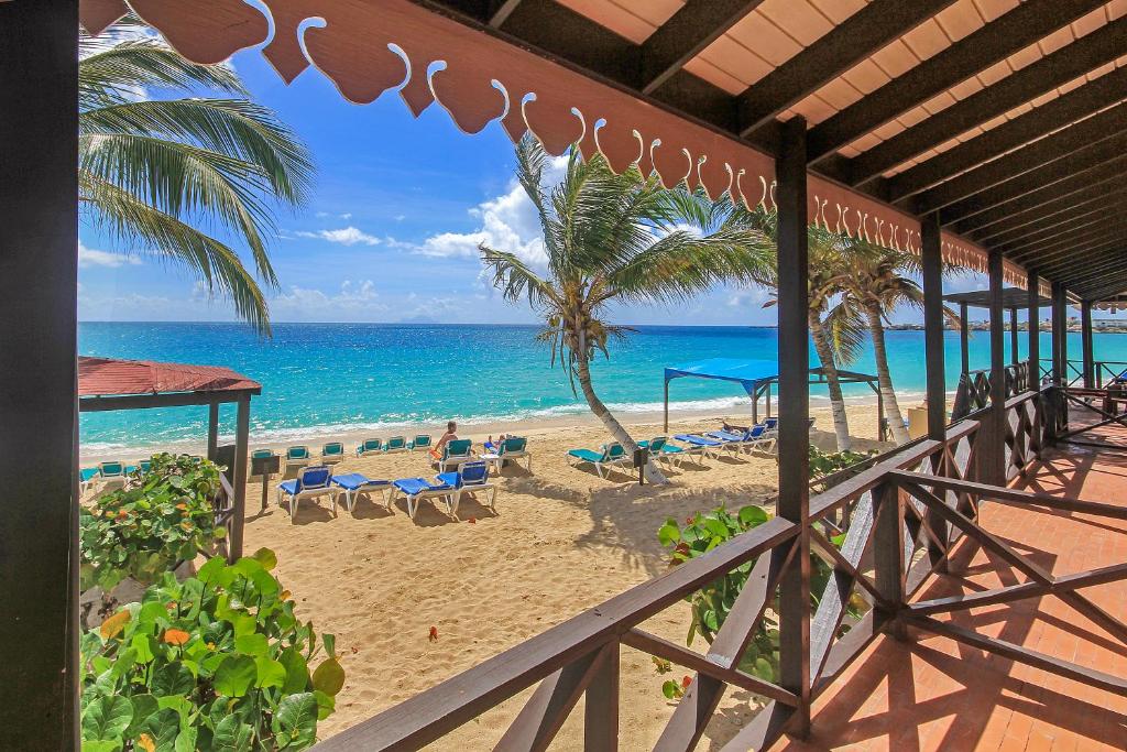 - une vue sur la plage avec un palmier et l'océan dans l'établissement Mary's Boon Beach Resort & Spa, à Simpson Bay