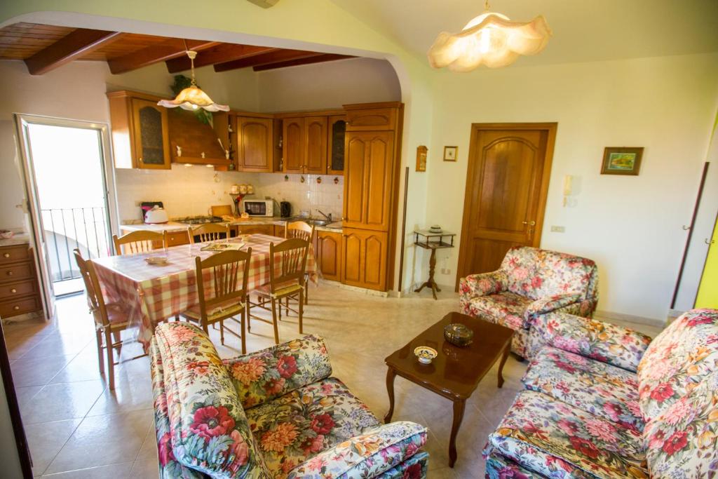 een woonkamer met een tafel en stoelen en een keuken bij Marylin in Cefalù