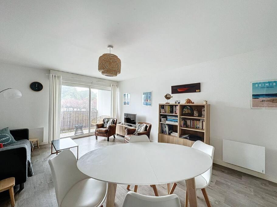 un salon avec une table et des chaises blanches dans l'établissement Appartement tout confort proche plage, à Mesquer
