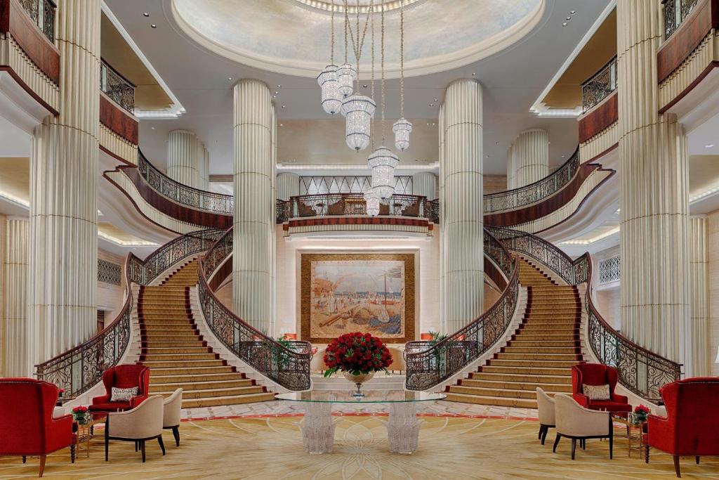 a large lobby with stairs and a vase of flowers at The St. Regis Abu Dhabi in Abu Dhabi