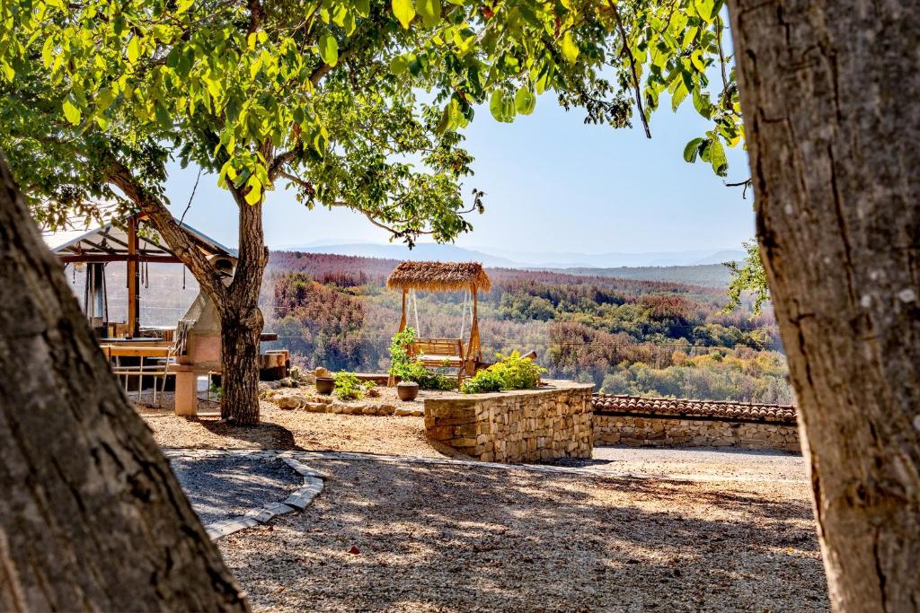 a view of a park with a bench and trees at Complex ARBANASHKI STYLE-Panoramic View with Summer and Winter terrace, Children's Area and PLAYING SALA in Arbanasi