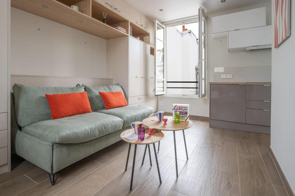 - un salon avec un canapé vert et 2 tables dans l'établissement Studio Temple - Welkeys, à Paris