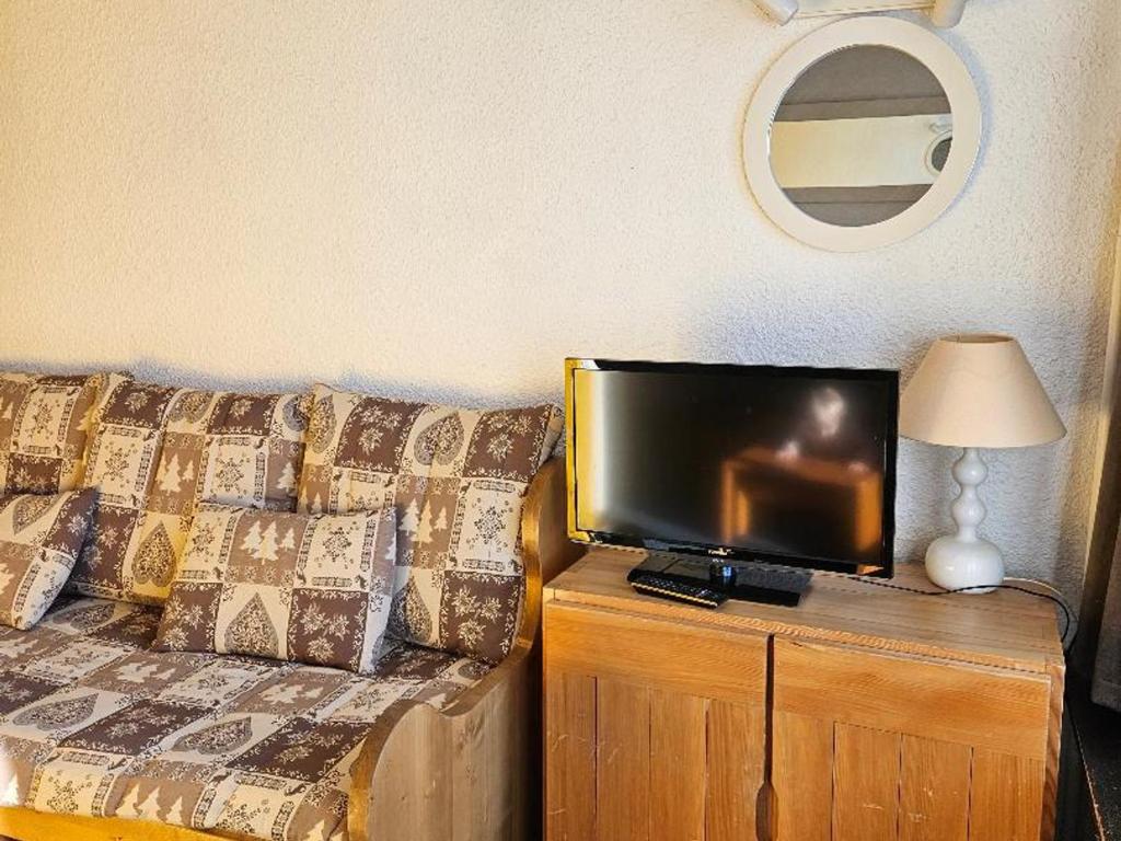 un salon avec un canapé et une télévision à écran plat dans l'établissement Charmant 4p, Wi-Fi, animaux admis, Les Menuires - Croisette - FR-1-574-33, aux Menuires