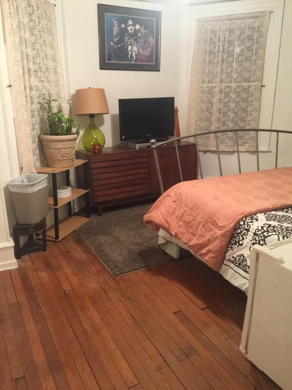 a bedroom with a bed and a desk with a television at Black Oak Rest in Philadelphia