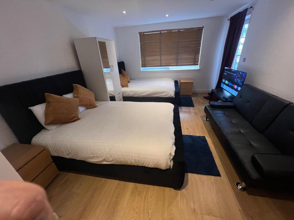 een kleine kamer met 2 bedden en een bank bij The O2 Arena ExCel Canary Wharf London in Londen