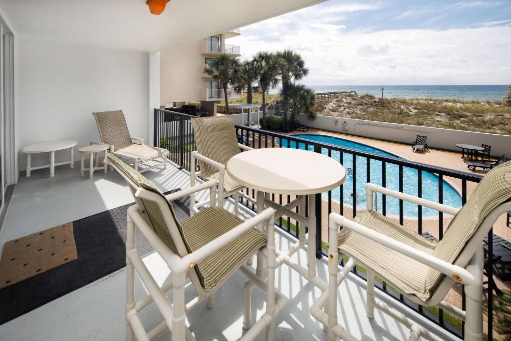 a balcony with chairs and a table and a pool at Dune Pointe 201 in Fort Walton Beach